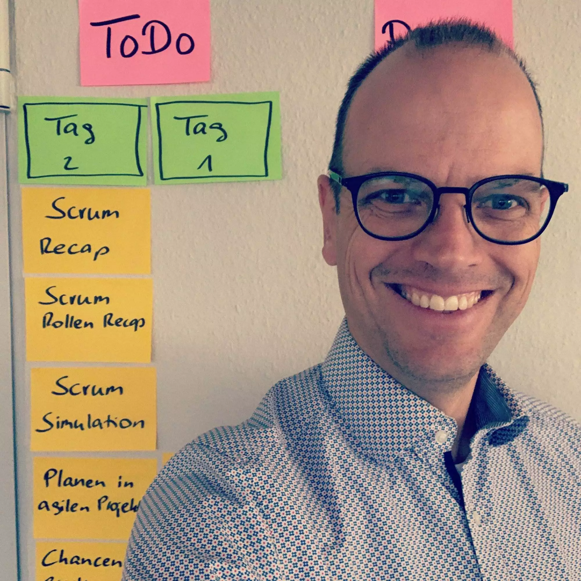 Foto von Marc Löffler vor Wand mit Post it Klebezetteln
